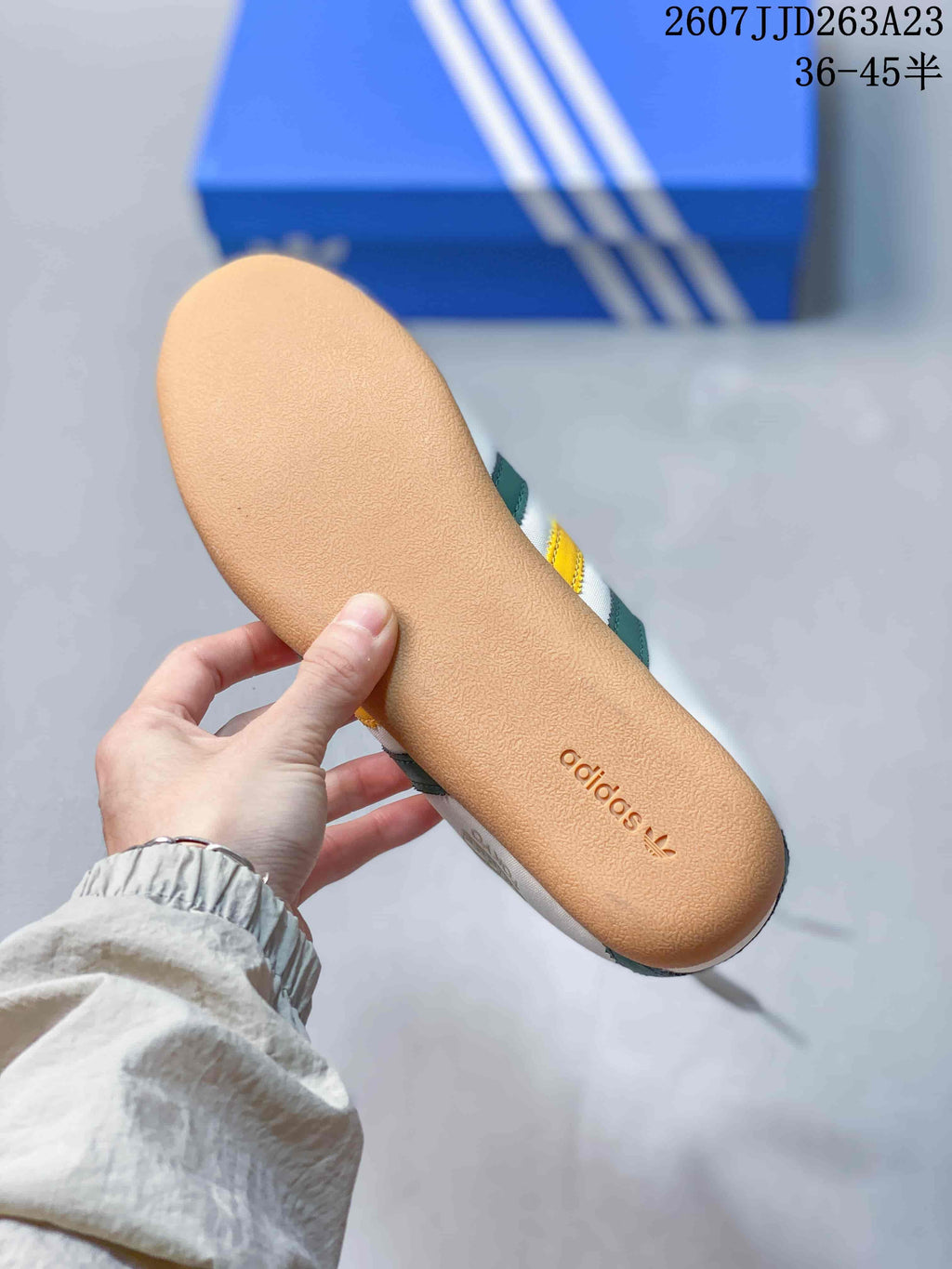 Gum-colored outsole of the sneaker showing embossed adidas branding.