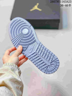 Outsole view showing the circular and linear tread pattern on a light grey and white sneaker.
