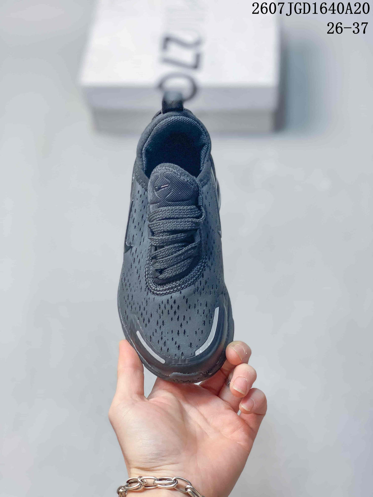 Top view of the black sneaker showing the perforated toe area, padded tongue, and laces.