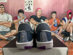 Rear view of dark gray Nike basketball shoes with light gray midsoles and purple outsole accents.