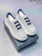 Pair of light gray ECCO slip-on sneakers with navy crossover bands displayed on a branded box; style code 2607GGD513A23 and size range 38–44 are visible.
