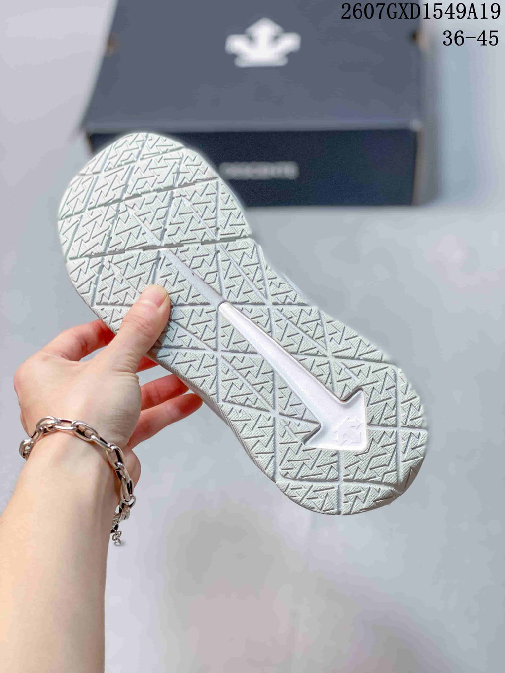 Close view of the white sneaker outsole showing a geometric traction pattern.