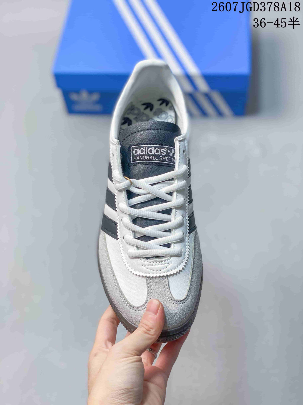 Top view of the sneaker showing white laces, gray toe overlays, and a branded tongue.