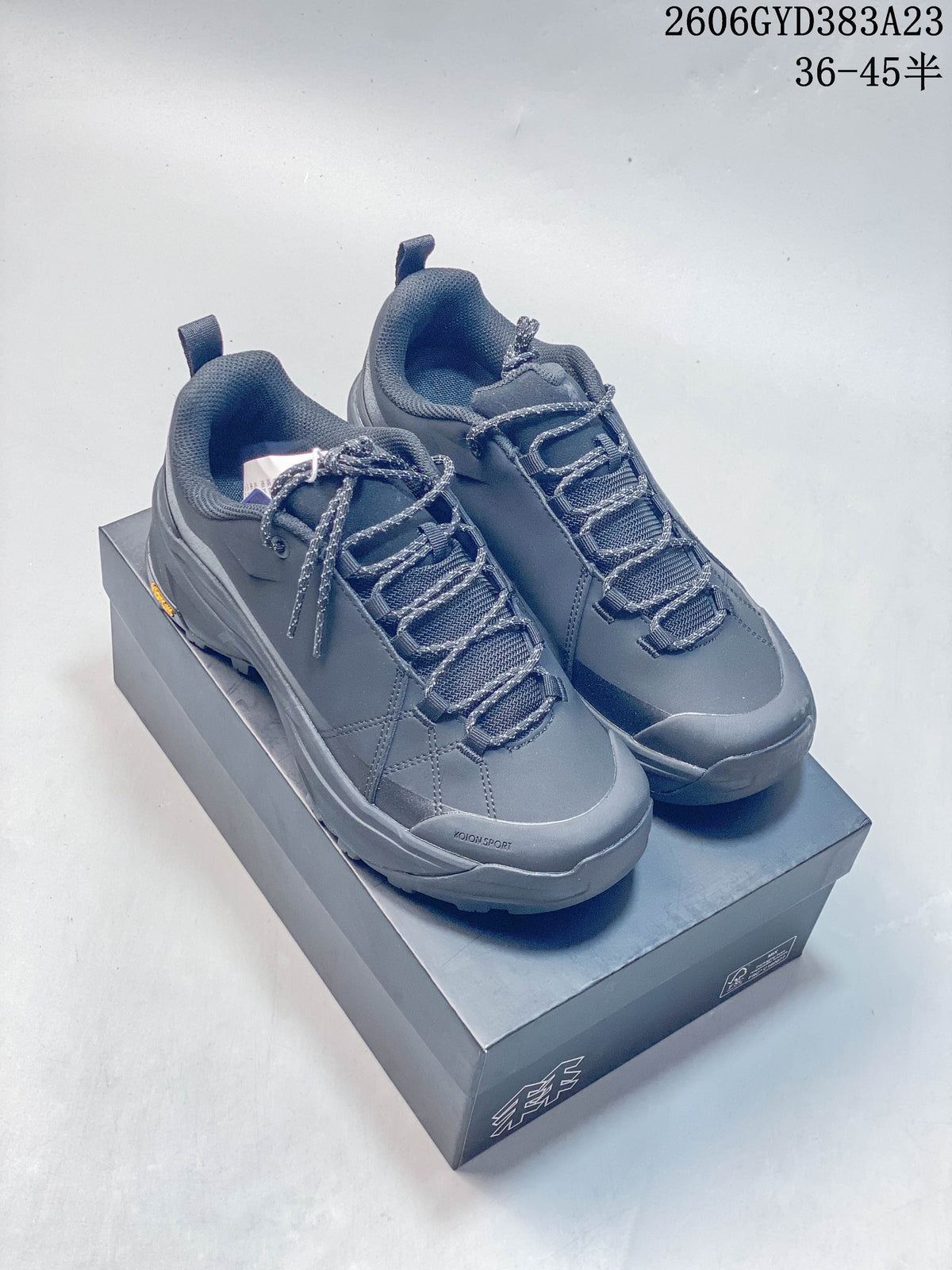 Pair of dark gray Kolon Sport low-top hiking shoes on a shoebox