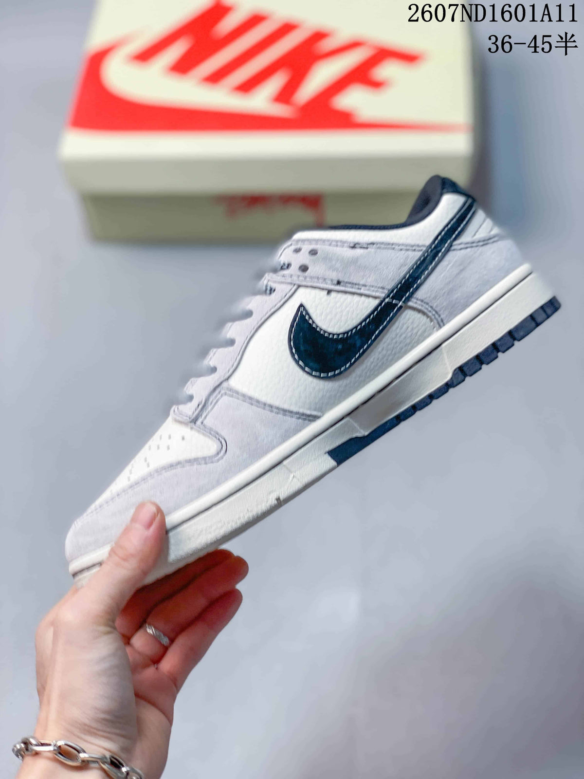 Side profile of the white and navy low-top sneaker showing the Swoosh, layered panels, and contrasting outsole.