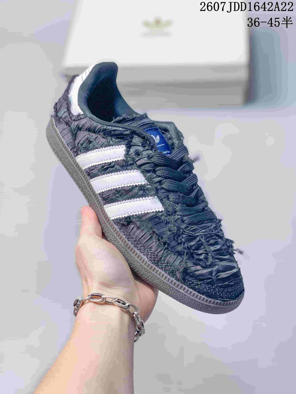Close-up side view of a black ruched adidas Samba OG sneaker with white three-stripe branding.