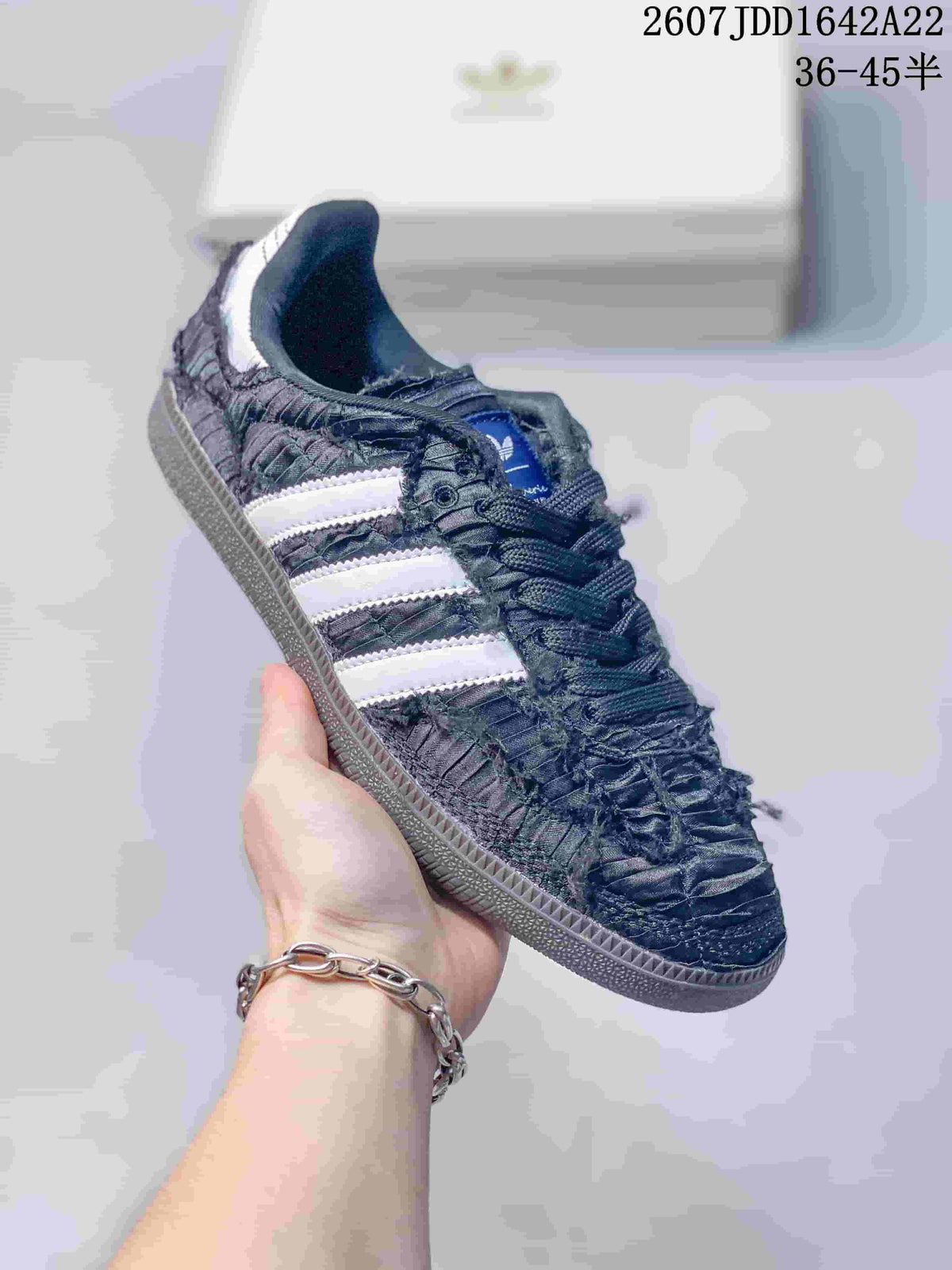 Close-up side view of a black ruched adidas Samba OG sneaker with white three-stripe branding.