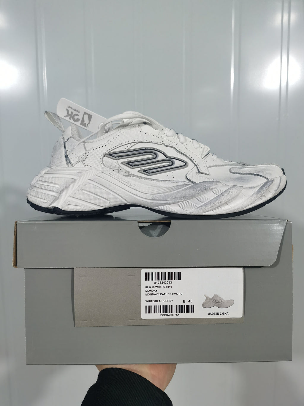 White sneaker displayed on its box; the label shows model 9110, a white/black/grey colorway, and size 40.