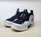Front three-quarter view of silver Nike Foamposite Pro shoes with black laces