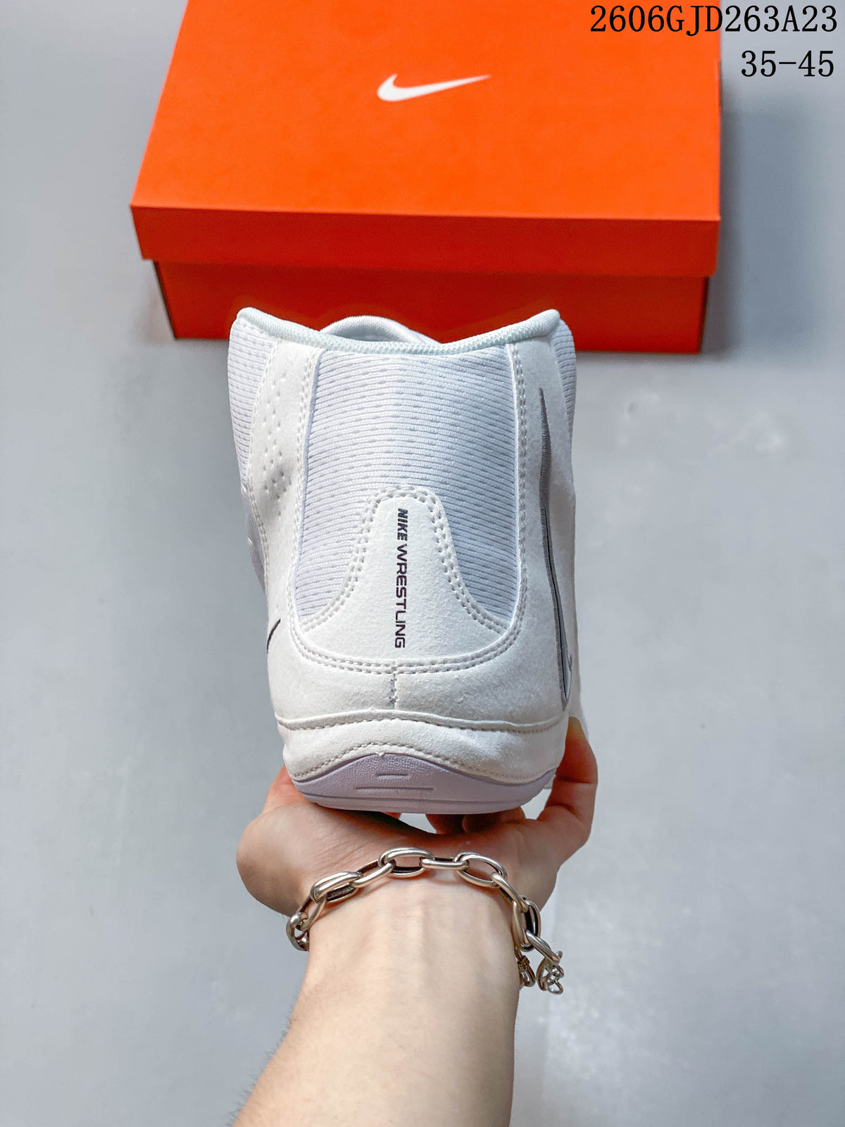 Rear view of a white Nike Inflict 4 wrestling shoe with Nike Wrestling branding.