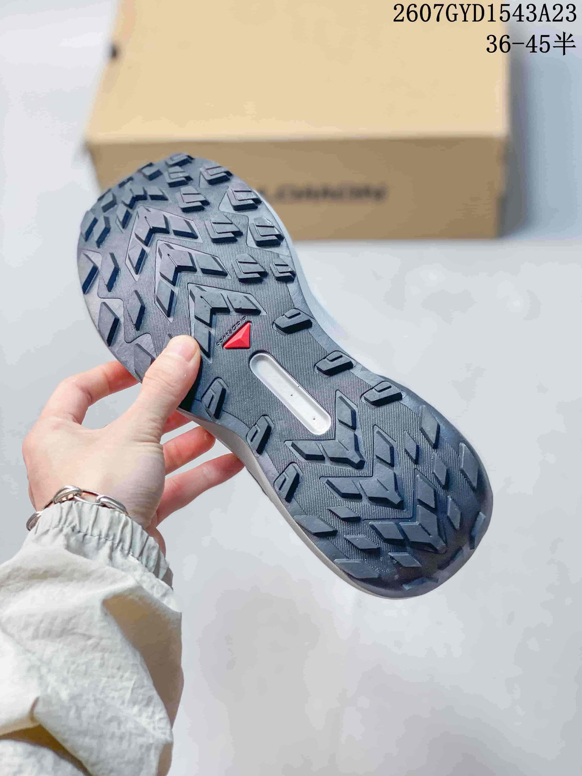 Close view of the shoe outsole showing a dark lugged traction pattern and central recessed detail.