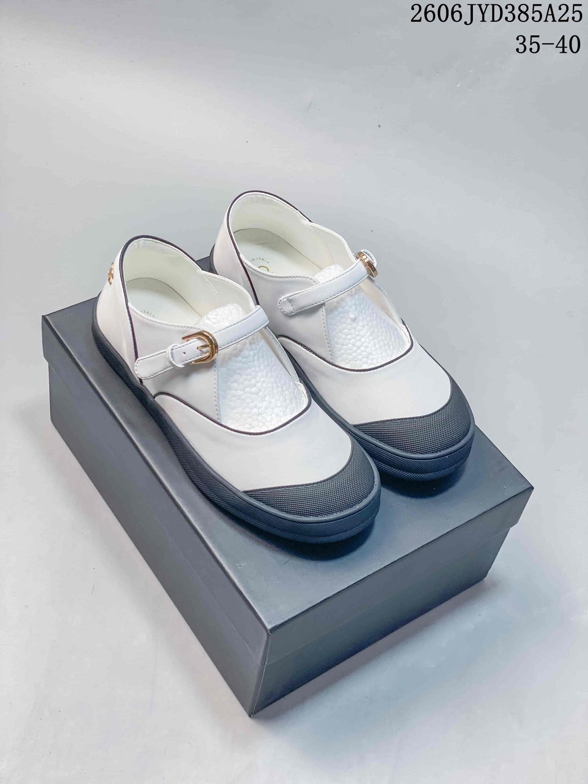 White Mary Jane flats with dark trim and buckle straps, photographed as a pair.