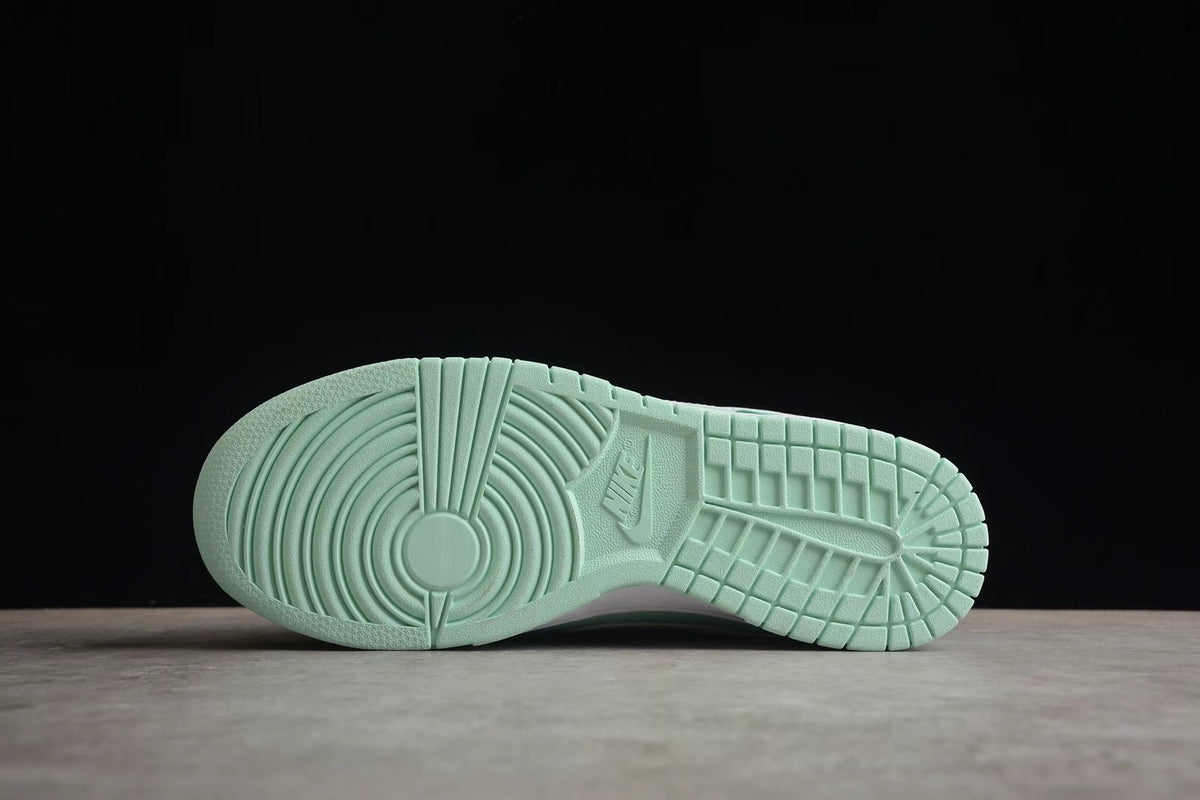 Underside view showing the mint green rubber outsole with circular forefoot grooves and grid-pattern tread.