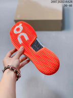 Close view of the bright orange outsole showing a repeating herringbone-style tread and central textured insert.