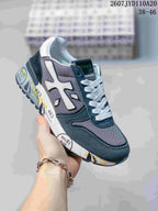 Angled side view of the Premiata sneaker showing the white side emblem, gray mesh panels, navy overlays, and graphic midsole.