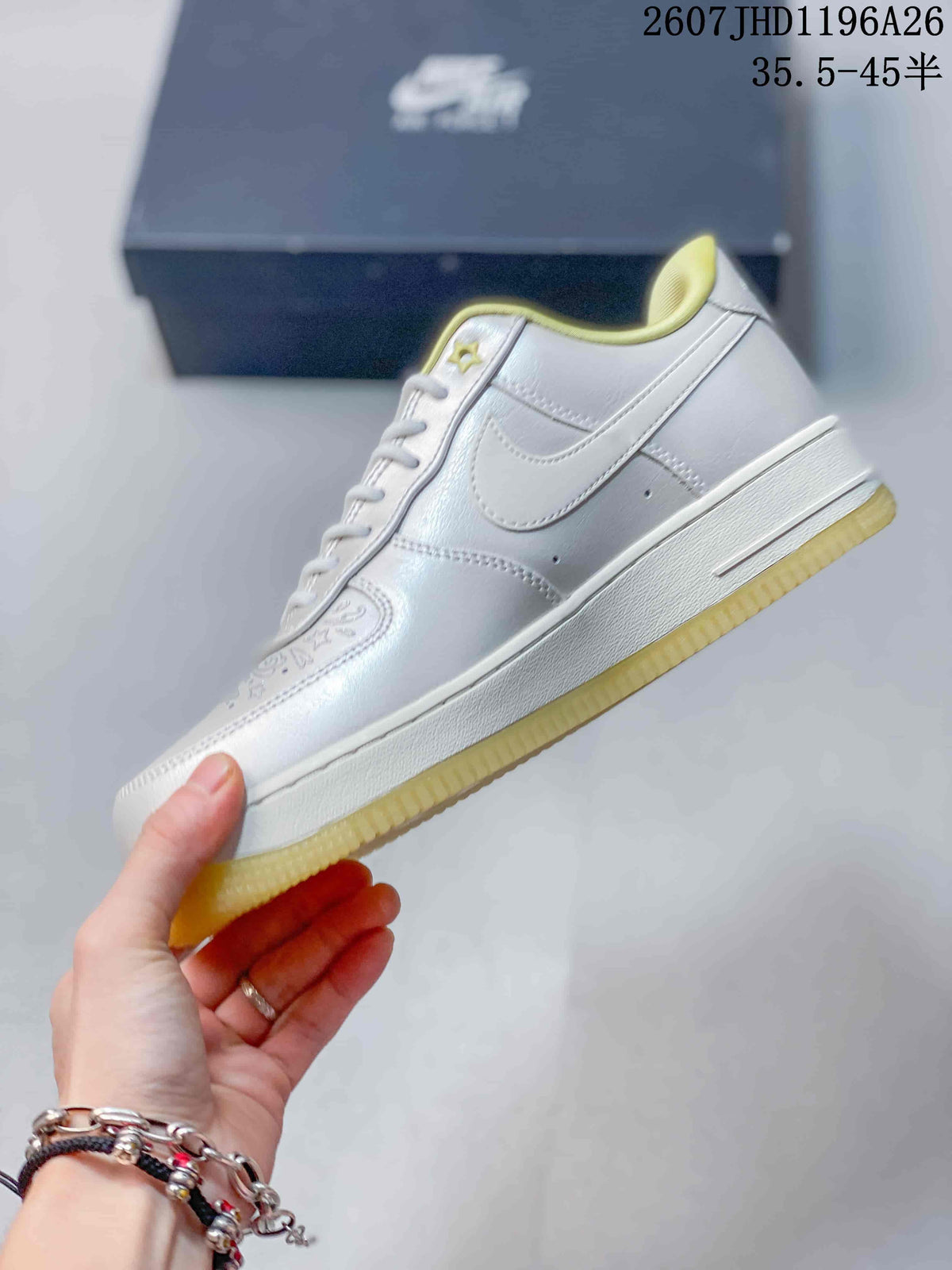 Side view of the white low-top sneaker showing the Swoosh, stitched panels, white midsole, and translucent yellow outsole.