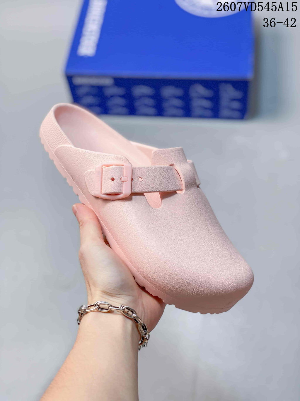 Angled front view of the pink sandal showing the buckle, closed toe and lugged outsole.