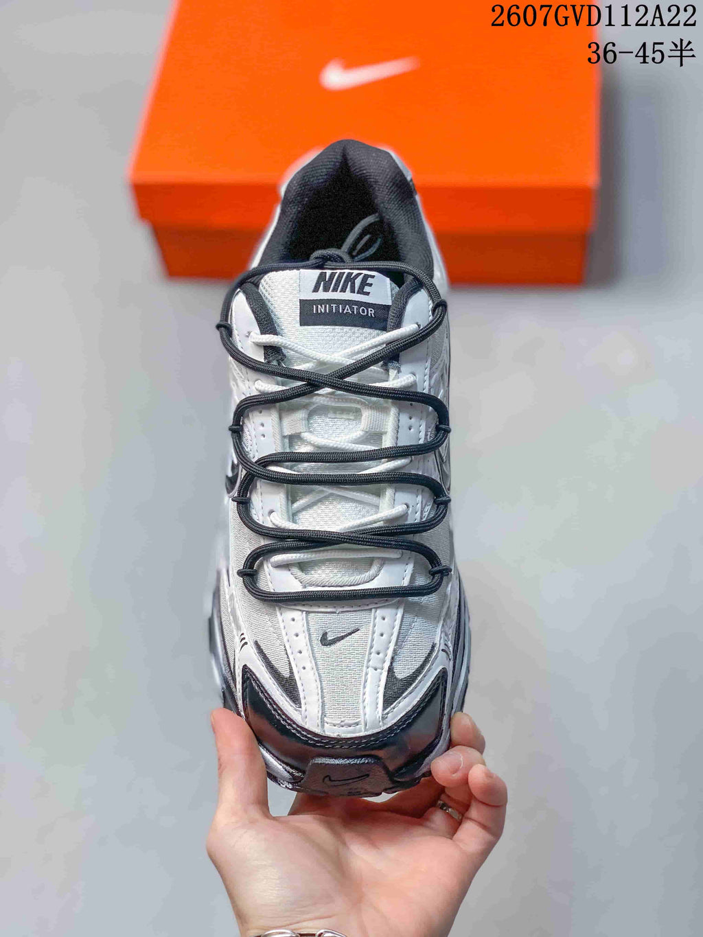 Top view of the sneaker showing the layered lace arrangement, perforated tongue area, and contrasting toe details.