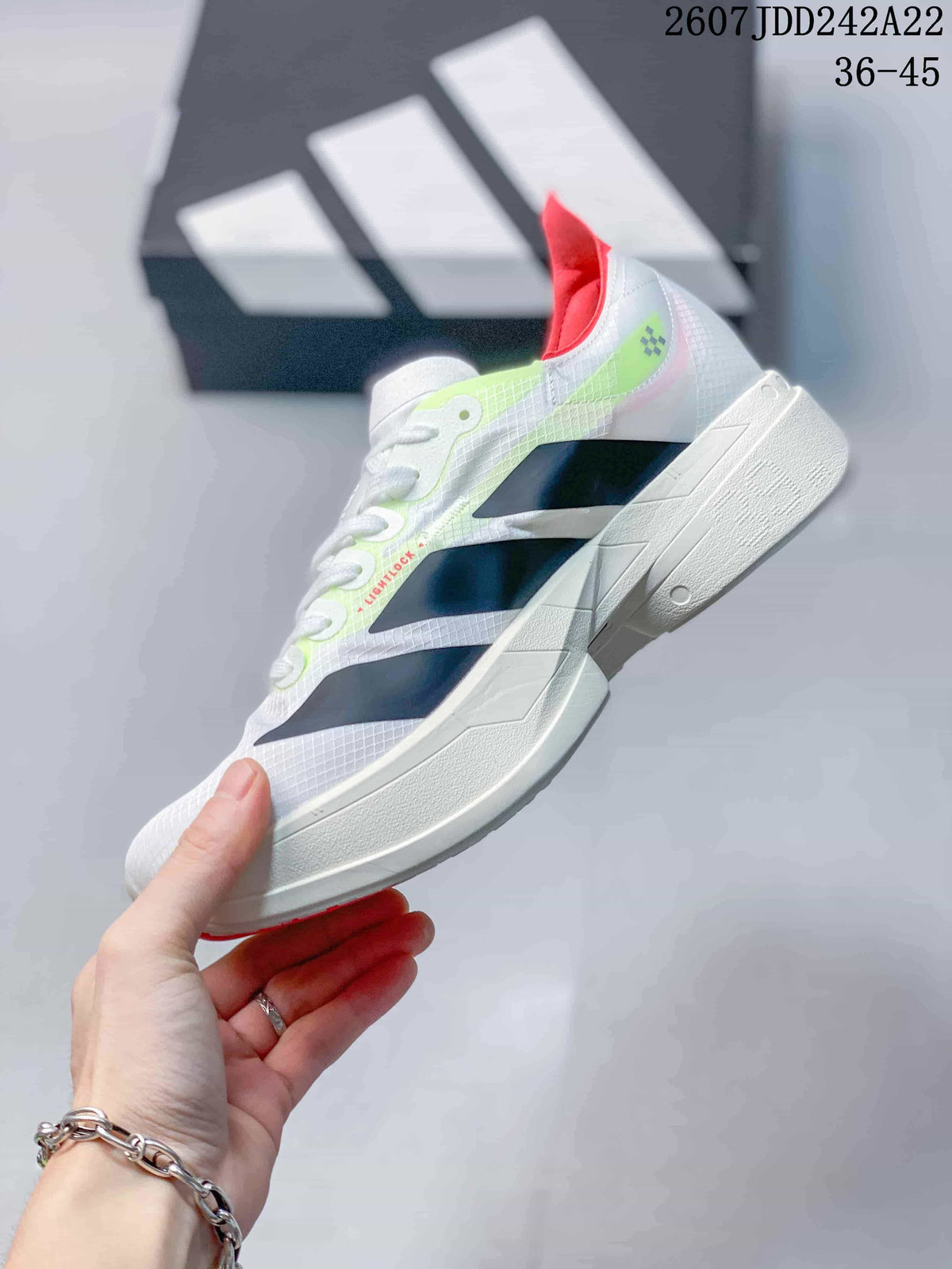 Side profile showing the white textured upper, black angular side panels, neon green accents, and sculpted white midsole.