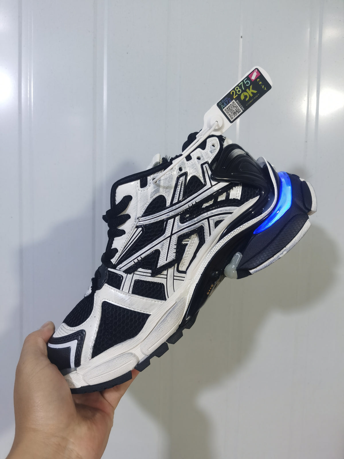 Side view of the Puma 9010 white and black runner sneaker showing its overlays, mesh-style panels and outsole.