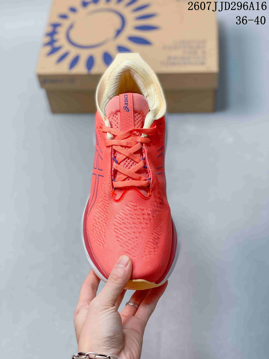 Top view of the coral pink lace-up running shoe showing the textured upper, tongue and cream padded collar.