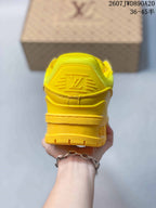 Rear view of the yellow sneaker showing the padded collar, heel branding and layered sole construction.