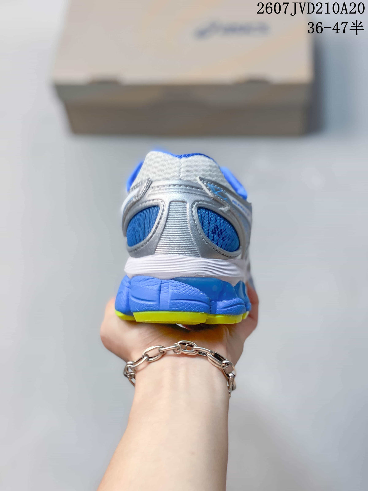Rear view of the sneaker showing the blue heel panel, white upper and lime outsole edge.