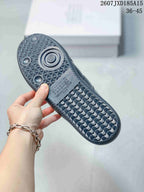 Close view of the textured rubber outsole with geometric tread and circular traction details.