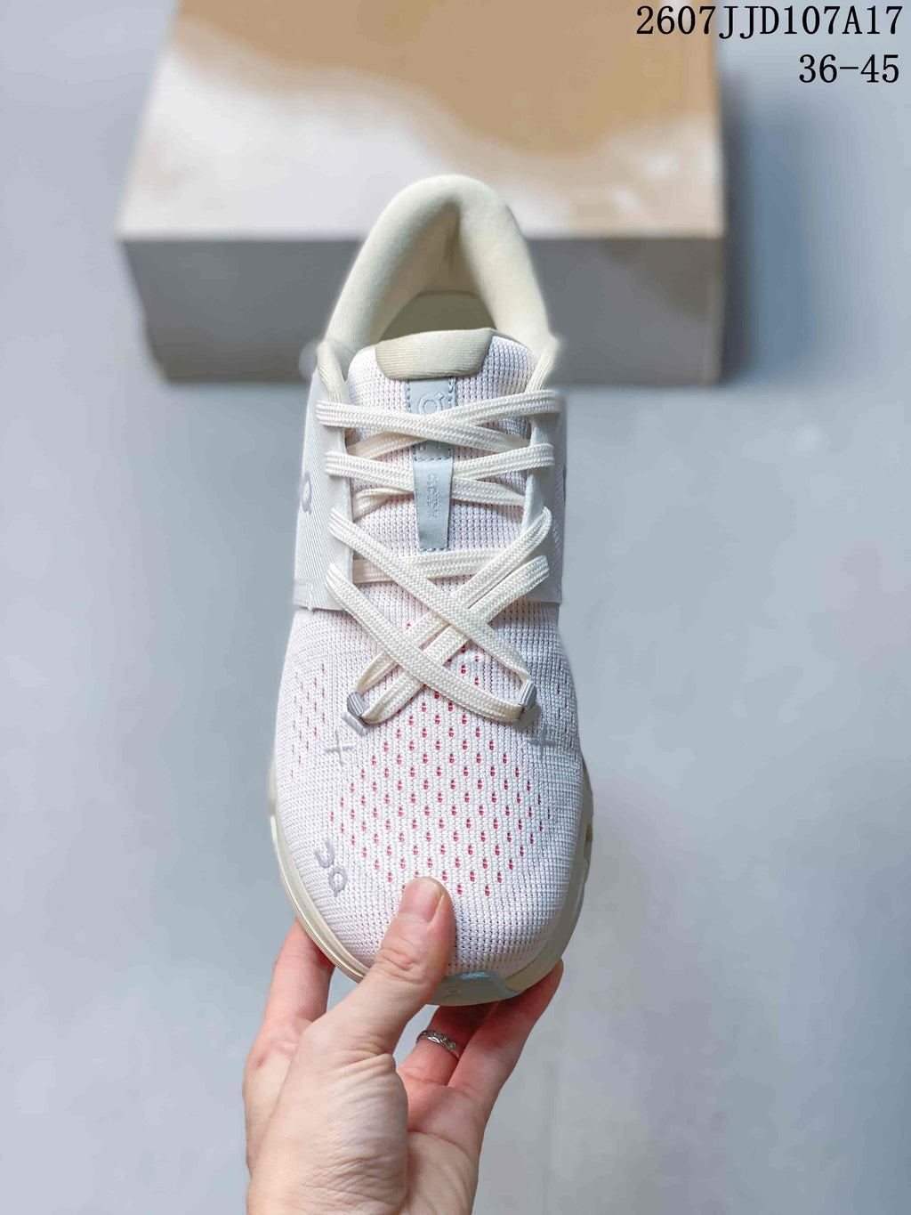 Top view of the sneaker showing the white knit-style upper, perforated toe area, laces and padded tongue.