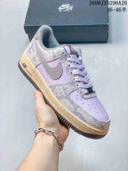 Close-up of a lavender Nike Air Force 1 sneaker with patterned overlays and a contrasting sole.