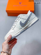 Side profile showing the white upper, gray patterned panel, gray Swoosh, white midsole, and gray outsole.