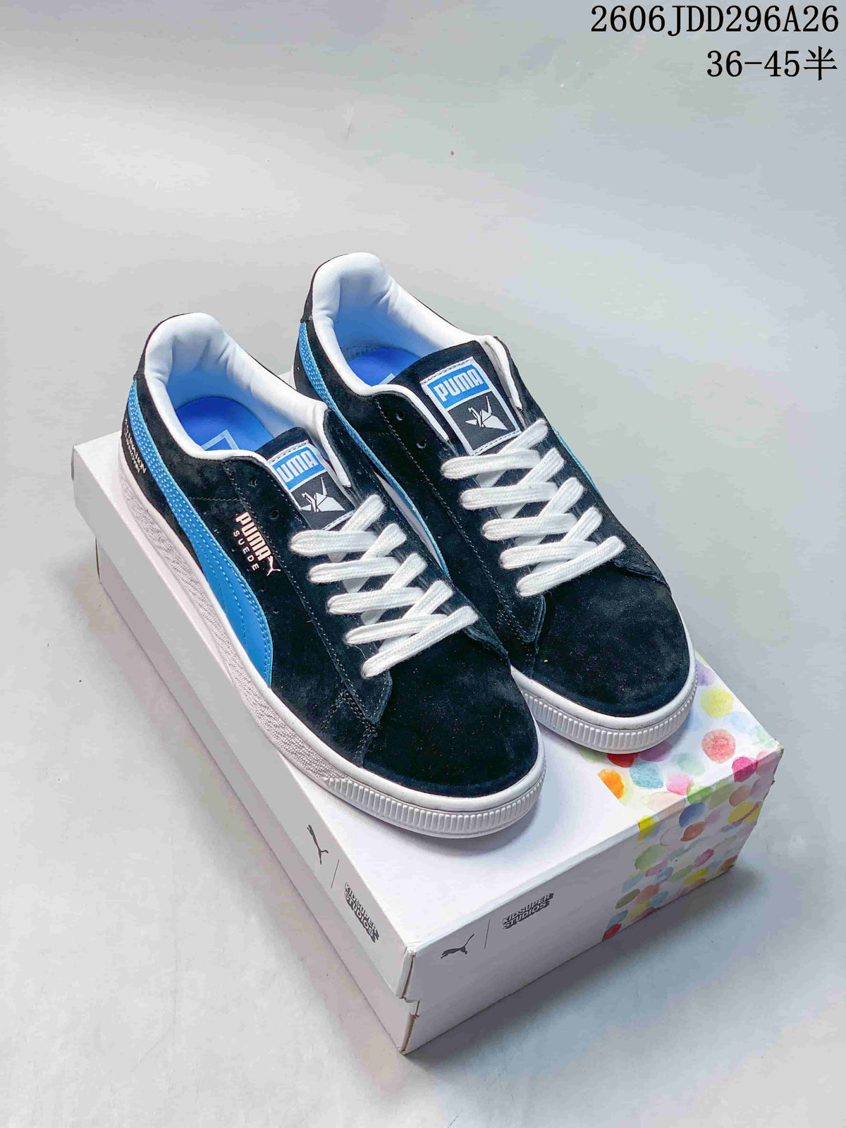 Pair of dark blue PUMA low-top sneakers with bright blue side stripes, white laces, and white soles displayed on a shoebox.