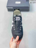 Top view of the black sneaker showing the tongue branding, metal eyelets, stitched toe panels, and light-colored lining.