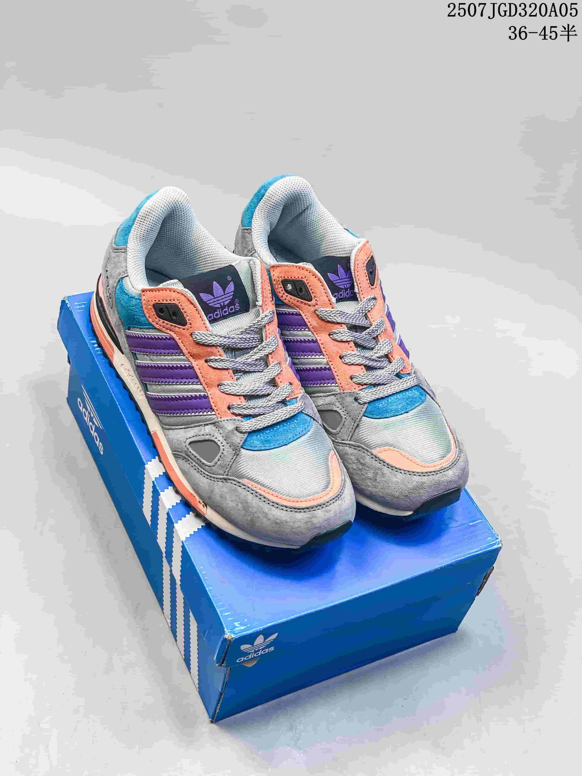 Pair of gray adidas ZX 750 sneakers with purple, blue and coral accents on a blue shoe box.