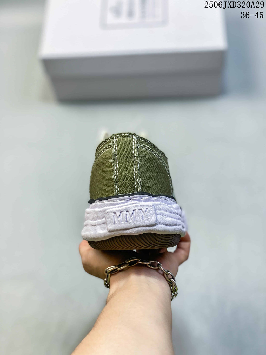 Rear view of an olive sneaker showing the stitched heel panel, MMY heel branding, white midsole, and brown outsole.
