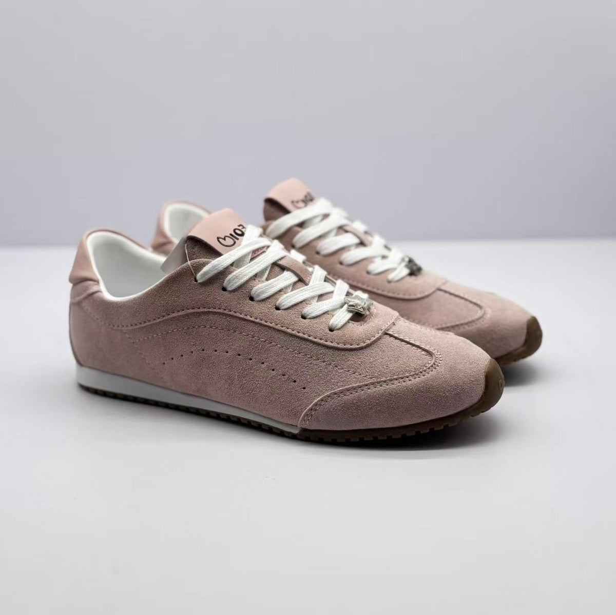 Pair of pink and white low-top sneakers shown from a three-quarter front angle.
