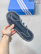 Underside of the sneaker showing a dark zigzag-pattern rubber outsole.