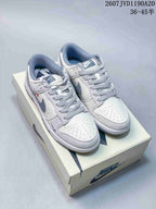 Pair of off-white Nike SB Dunk Low sneakers with gray-blue contrasting details and patterned laces on a shoe box.