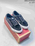 Pair of black Vans SK8-Low sneakers with skull-print laces displayed on a Vans shoe box.