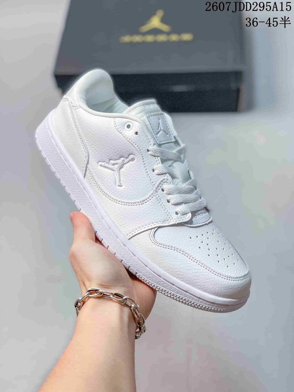Angled side view of the white Jordan low-top sneaker showing the lace-up construction, side logo and padded collar.