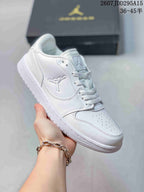 Angled side view of the white Jordan low-top sneaker showing the lace-up construction, side logo and padded collar.