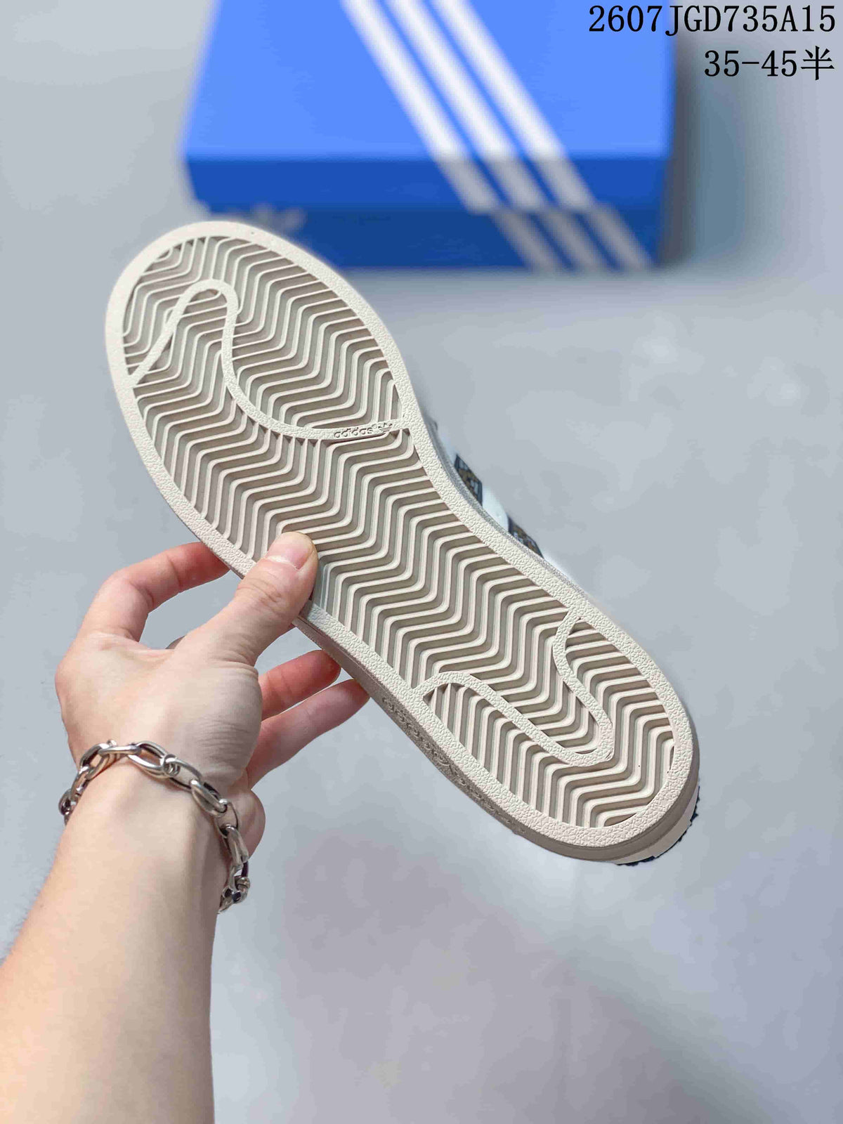Close-up of the sneaker outsole showing a light-colored herringbone tread pattern and adidas branding.
