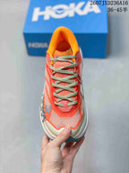 Top view of the coral and cream trail running shoe showing the lace-up closure, mesh toe box, and orange padded collar.