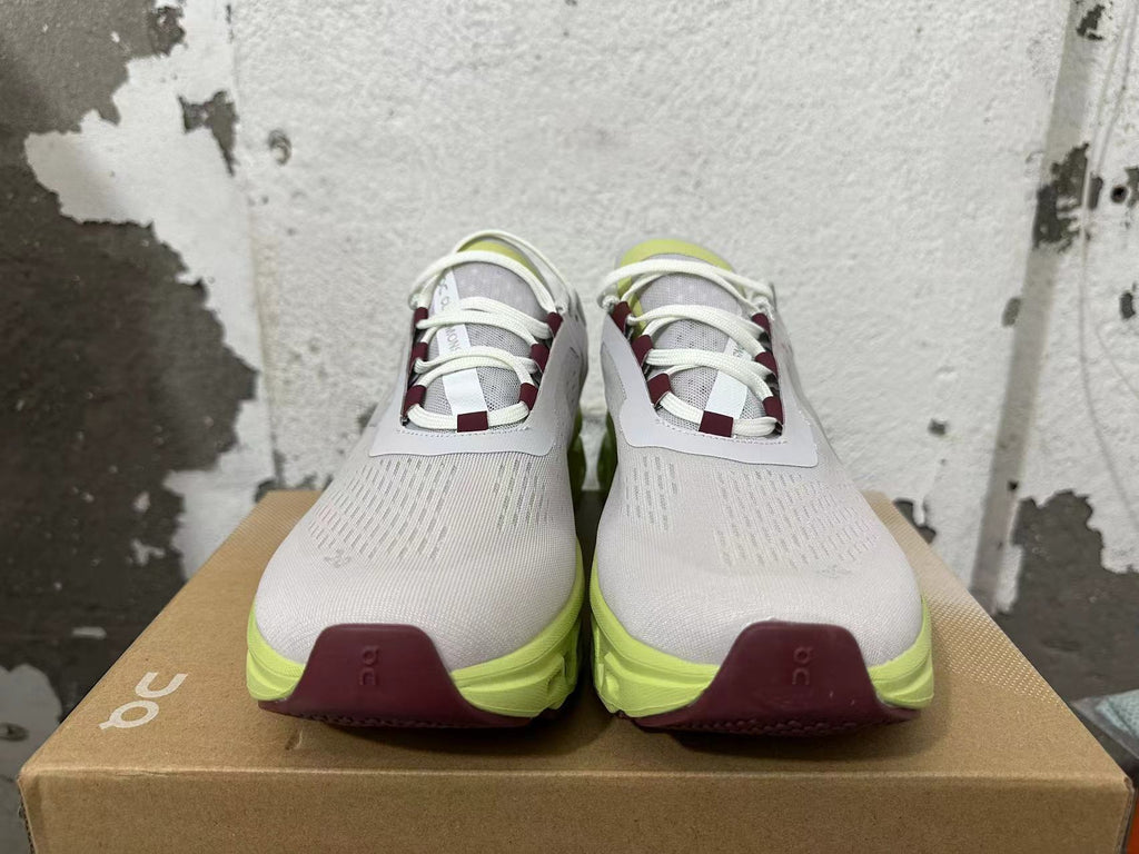 Front view of gray lace-up running shoes with burgundy lace accents