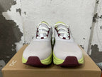 Front view of gray lace-up running shoes with burgundy lace accents