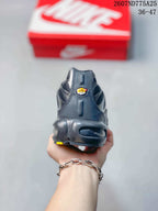 Rear view of a black Nike Air Max Plus TN sneaker showing the padded heel, outsole structure, and small yellow accent; overlay text shows code 2607ND775A25 and size range 36–47.