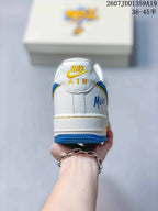 Rear view showing the white heel, Nike Air branding, blue outsole and Minions-themed side detail.