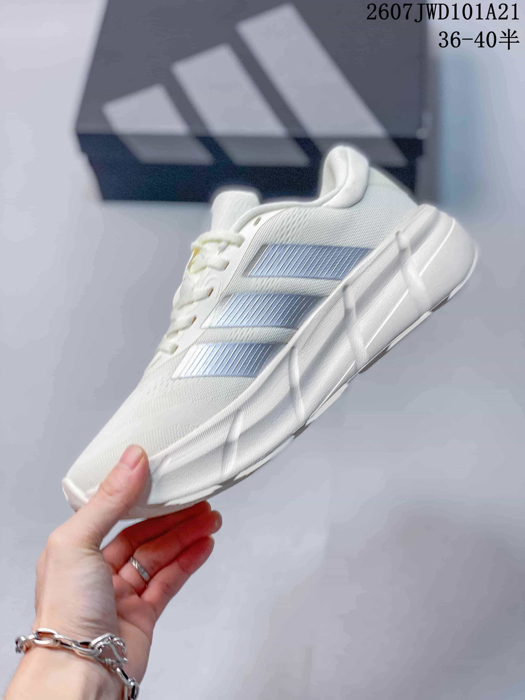 Side profile of the white low-top sneaker with silver three-stripe detailing, sculpted midsole and raised heel.
