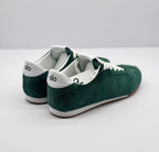 Rear three-quarter view of the green Alo sneaker pair with white heel accents and brown outsoles.