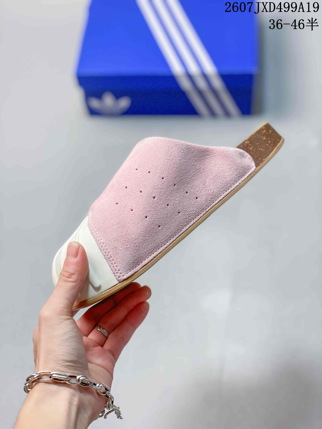 Side view of the pink adidas Adimule mule showing perforated upper panels, an off-white ribbed toe guard, and a gum-colored sole.